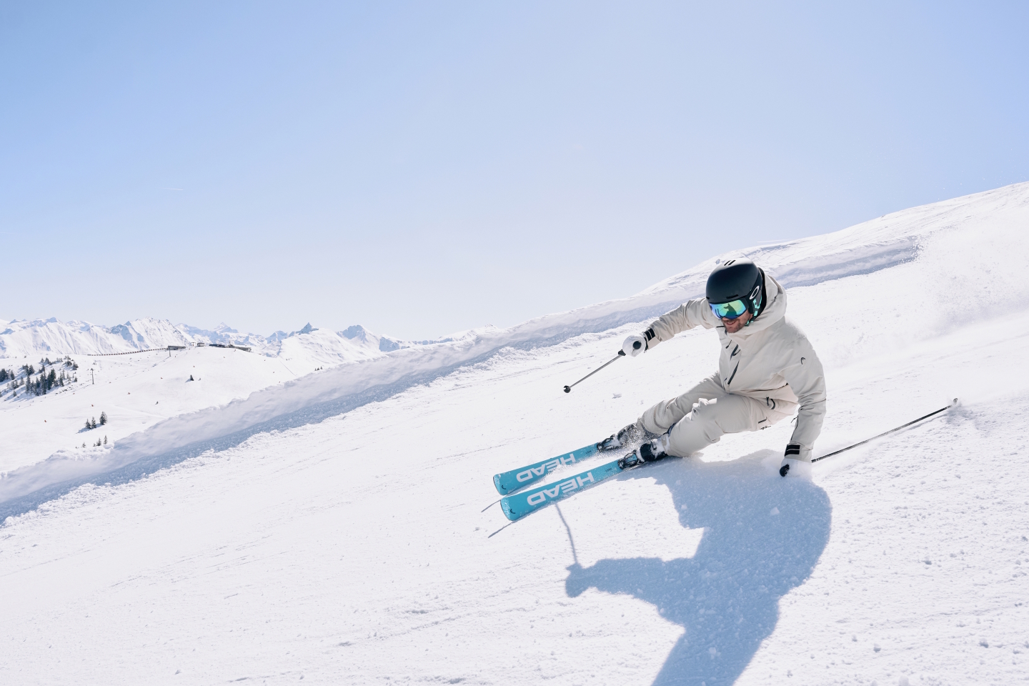 Skifahrer, der an einem sonnigen Tag einen verschneiten Berghang hinunterfährt. Wintersport und Freizeitaktivitäten im Freien.