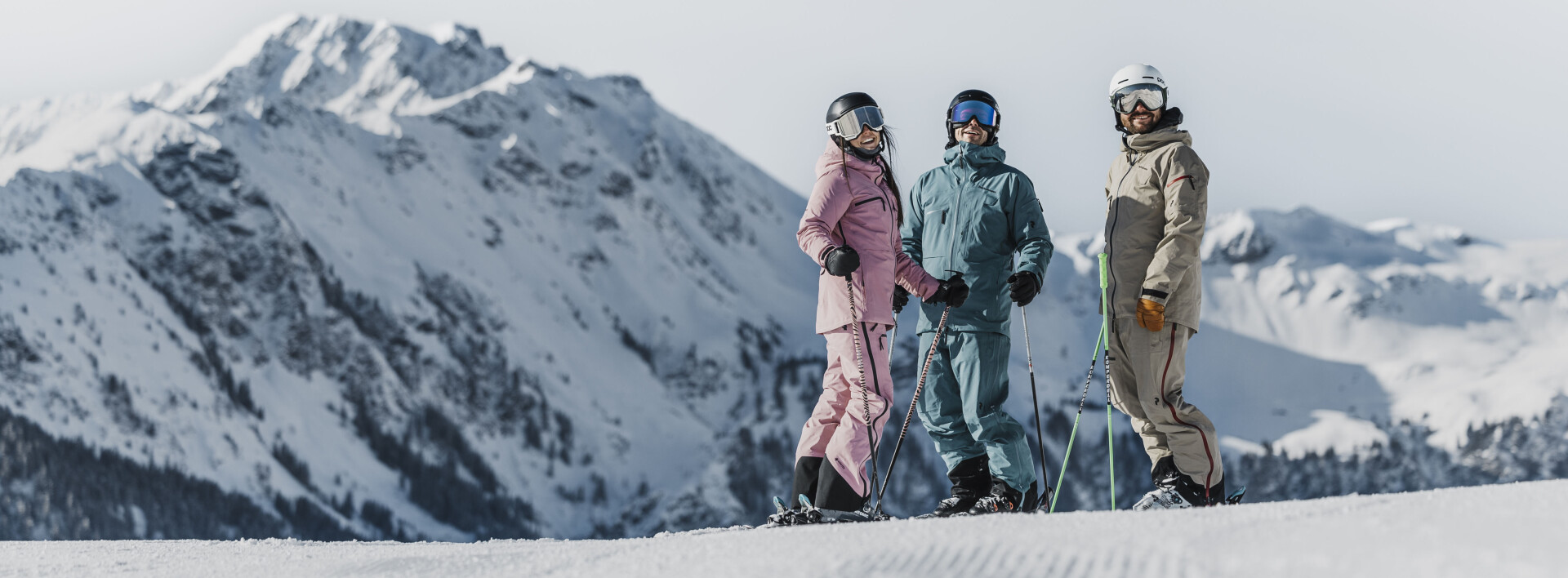 Skifahrer, der an einem sonnigen Tag einen verschneiten Berghang hinunterfährt. Wintersport und Freizeitaktivitäten im Freien.