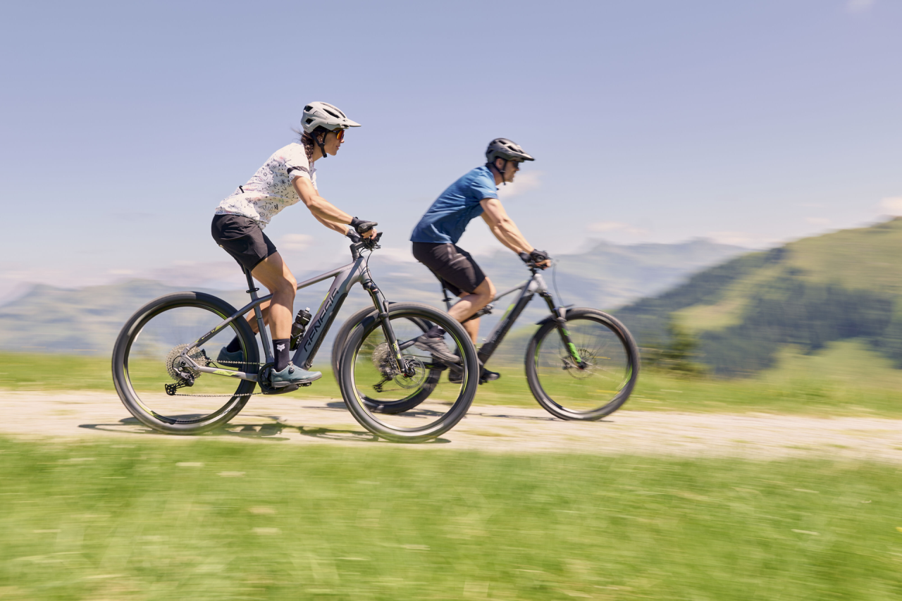 3 bikers ride down a trail on mountain bikes