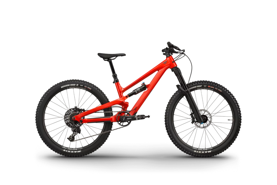 Leuchtend rotes Mountainbike mit dicken, profilierten schwarzen Reifen auf hellgrauem Hintergrund. Das Fahrrad verfügt über einen robusten Rahmen und ein modernes Design, das einen abenteuerlichen und dynamischen Eindruck vermittelt.