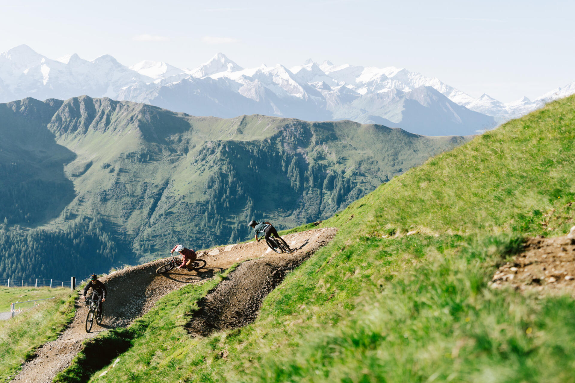 3 bikers ride around a bend on a bike trail.