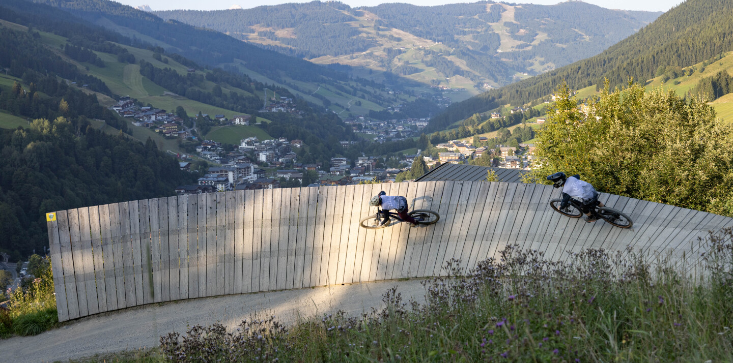 Skifahrer, der an einem sonnigen Tag einen verschneiten Berghang hinunterfährt. Wintersport und Freizeitaktivitäten im Freien.